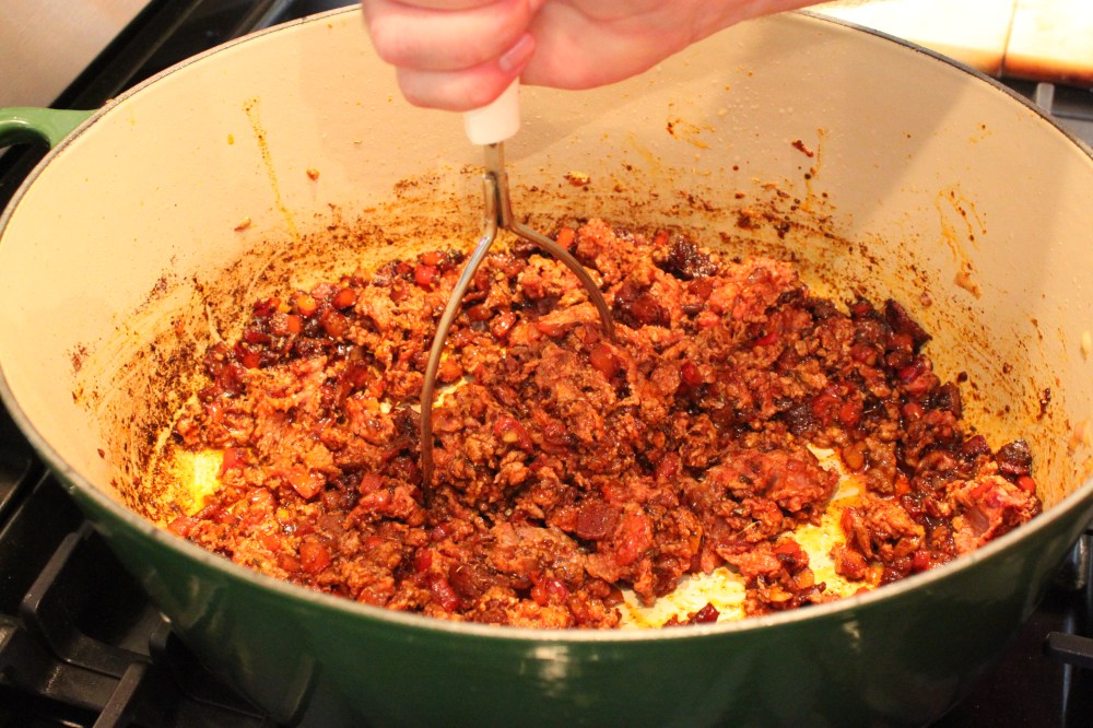 Add the Ground Meats and Chop with a Potato Masher