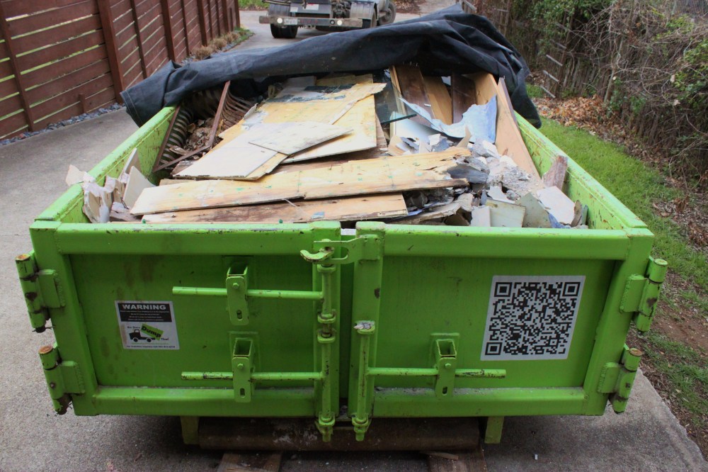 Green Dumpster Filled with all the Bathroom Debris