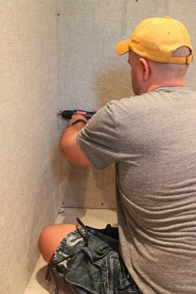 Jamie Uses an Electric Drill to Pre-Drill Holes for the Screws